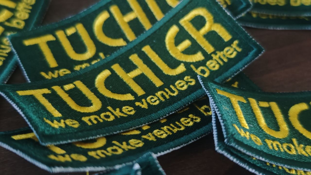 Grün-gelbe Firmenaufnäher mit gesticktem Schriftzug