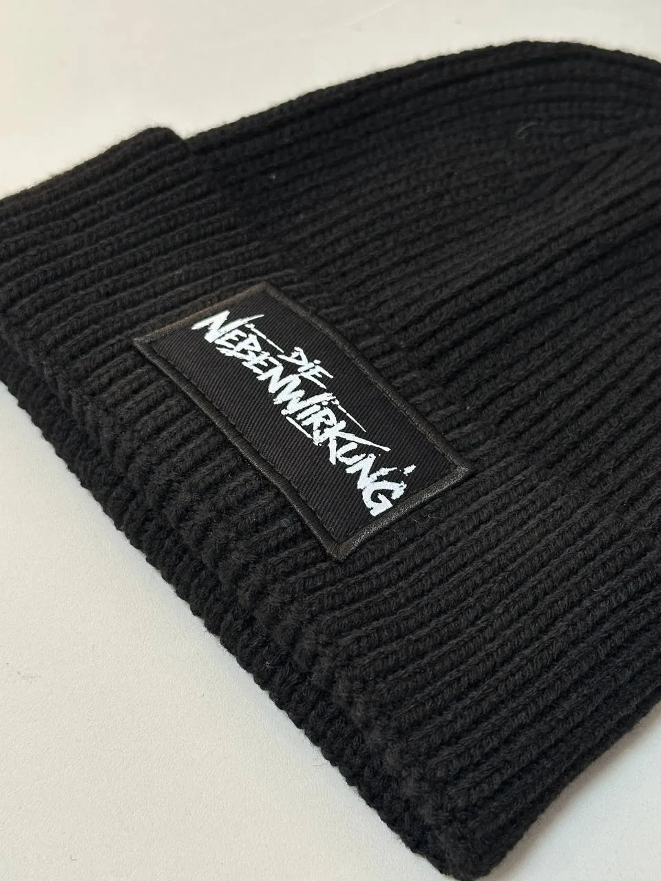 Schwarze Strickmütze mit aufgenähtem Logo-Patch in Weiß