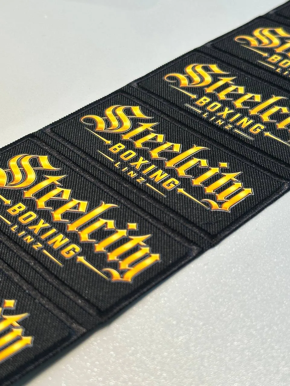 Bedruckte Logo-Patches in Gelb auf Schwarz als Serie