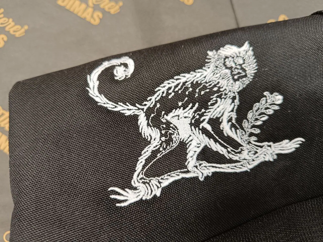 Detailstickerei Affe auf schwarzem Textil – filigrane Weißstickerei