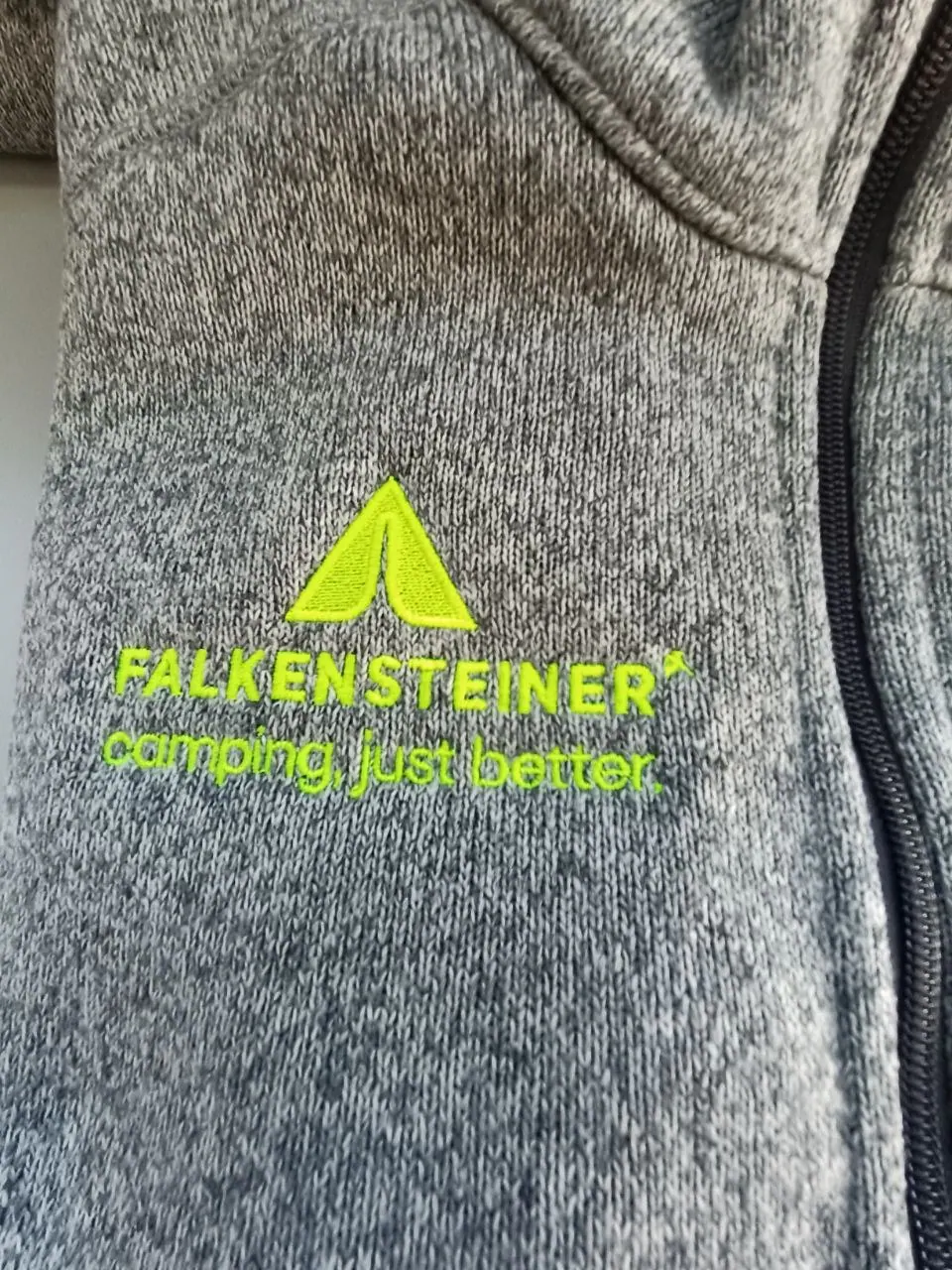 Direktstickerei in Neon-Gelb auf grauer Outdoor-Fleecejacke – Logo gestickt