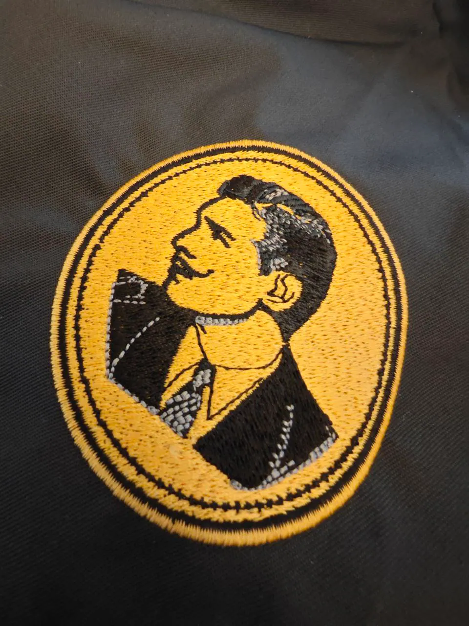 Gesticktes Porträt gold-schwarz auf Textil – ovaler Direktstick Retro-Motiv