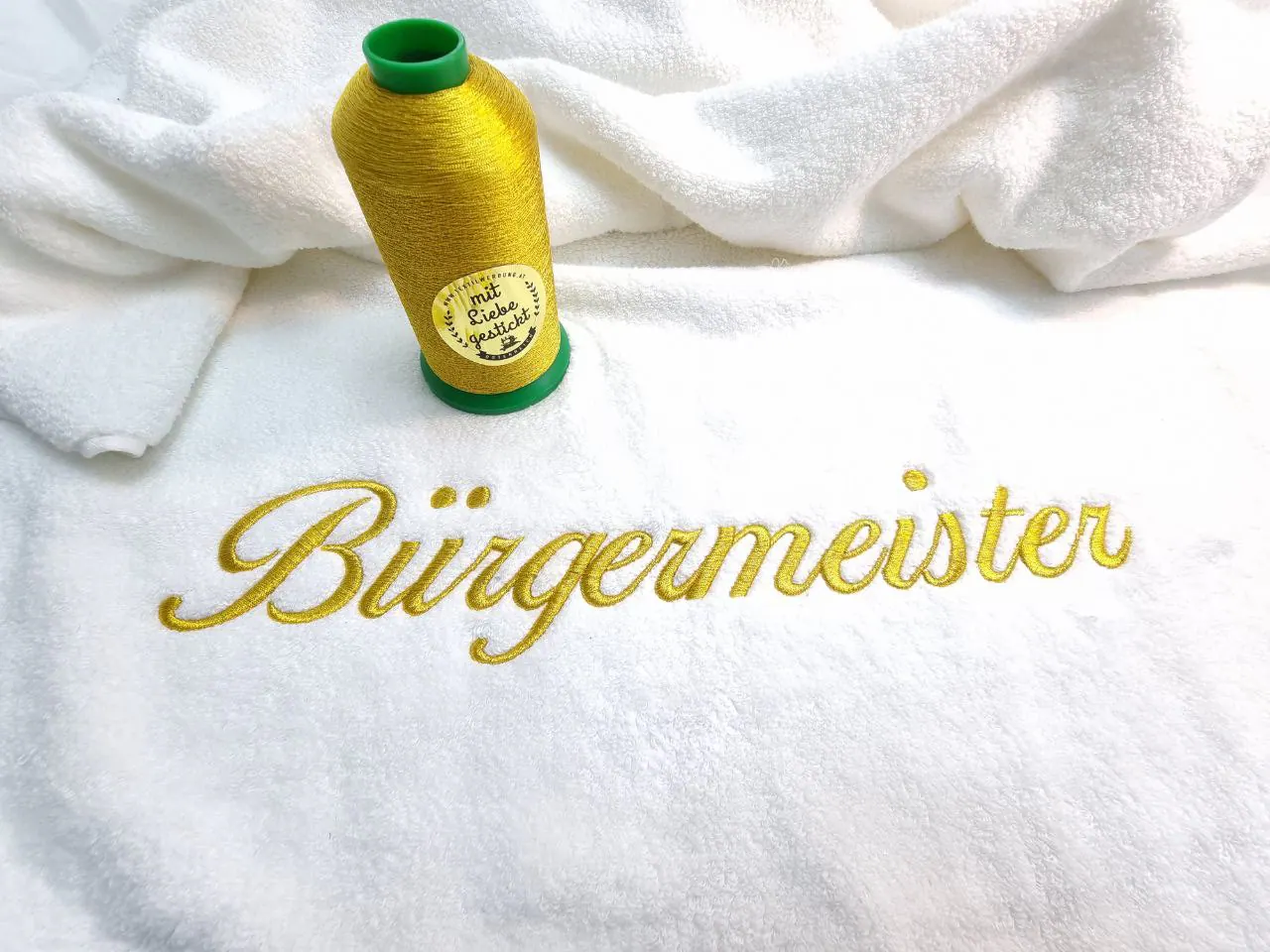 Bürgermeister goldene Textstickerei auf weißem Frottee-Handtuch mit Garnrolle