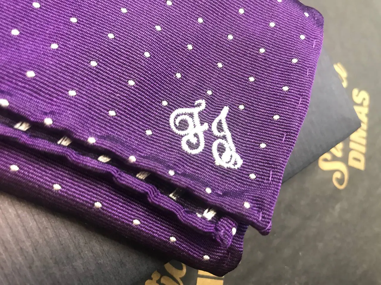 Monogramm-Stickerei auf lila Einstecktuch – weiße Initialen auf Seide