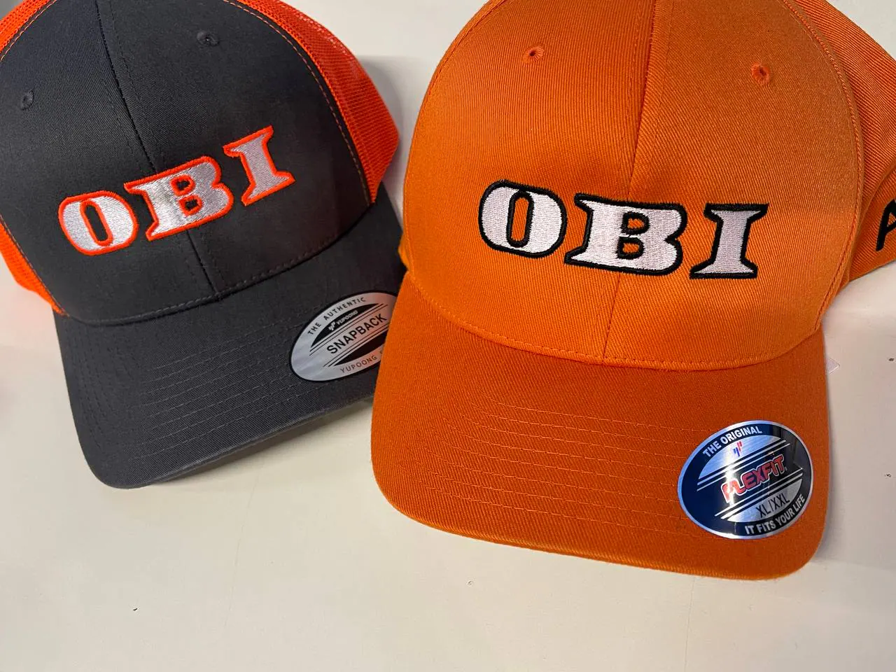 OBI bestickte Kappen orange-schwarz – Flexfit und Snapback Logo-Stickerei