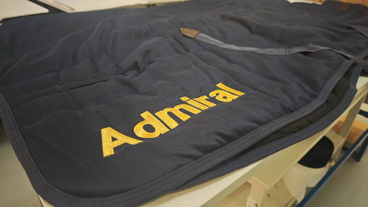Admiral bestickte Pferdedecke dunkelblau – goldene Textstickerei Nahaufnahme