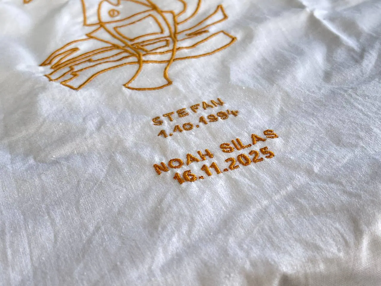 Besticktes Taufkleid mit Namen und Datum – personalisierte Taufstickerei gold